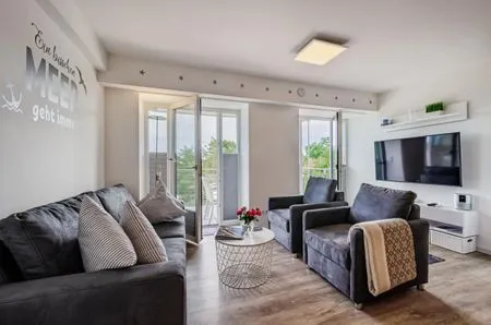 Wohn/Essbereich: Sofa, Sitzbereich, Essbereich, TV, Zugang zum Balkon FeWo Auszeit in PRORA - 9.42