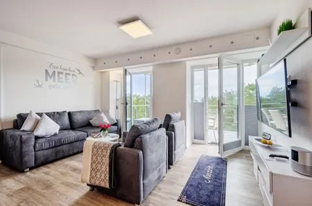 Wohn/Essbereich: Sofa, Sitzbereich, Essbereich, TV, Zugang zum Balkon FeWo Auszeit in PRORA - 9.42