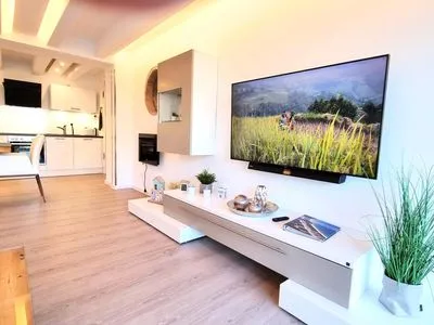 Wohnzimmer: Essbereich, Schlafsofa, Elektro-Kamin, Smart- TV, Zugang zum Balkon FeWo Treibgut in PRORA - 8.12
