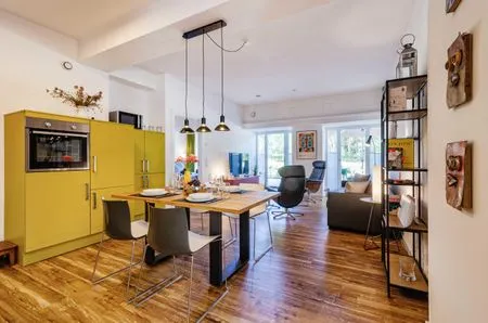 Offener Wohnbereich mit Zugang zur Terrasse, integrierter Küche, Esstisch, ausziehbarer Couch, Relaxsesseln, Smart-TV FeWo Dünenterrasse in PRORA - 9.04