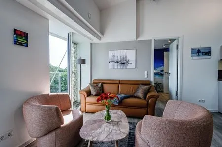 Wohn/Essbereich: Sofa, Sitzbereich, Essbereich, TV, Zugang zum Balkon FeWo Horizont in PRORA - 5.54