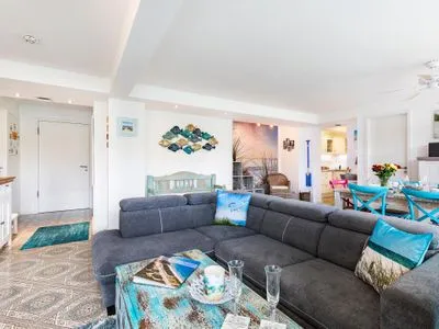 Wohn/Essbereich: Sofa, Sitzbereich, Essbereich, TV, Zugang zum Balkon FeWo Strandmuschel in PRORA mit Strandkorb am Strand & Balkon - 8.32