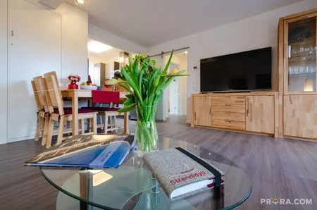 Wohn/Essbereich: Couch und Sessel, TV, Zugang zum Balkon FeWo Strandidyll in PRORA - 9.31