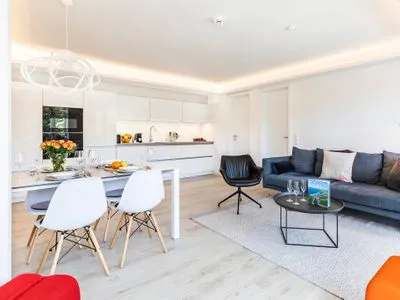 Wohn/Essbereich: Sofa, Sessel, TV, Zugang zum Balkon FeWo MariSol in PRORA Strandnah mit Meerblick & Sauna - 5.22