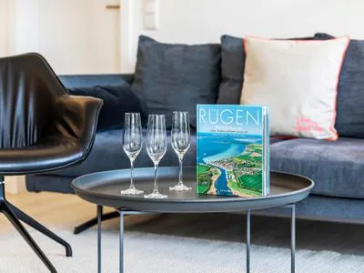 Wohn/Essbereich: Sofa, Sessel, TV, Zugang zum Balkon FeWo MariSol in PRORA Strandnah mit Meerblick & Sauna - 5.22