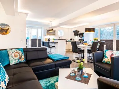 Wohn/Essbereich: Schlafcouch, Sitzbereich, Essbereich, Elektrokamin mit Heizfunktion, TV FeWo Meer geht immer in PRORA - 4.37