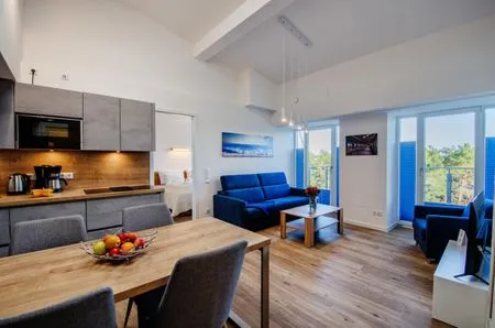 Wohn/Essbereich: Couch und Sessel, TV, Zugang zum Balkon mit Tisch und Stühlen FeWo Meerestraum in PRORA - 5.53