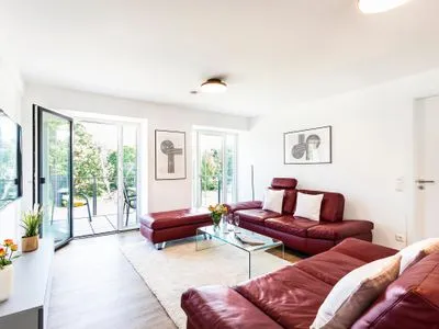 Wohnzimmer: 2 Sofa, TV, Zugang zum Balkon FeWo Oase in PRORA - 2.25