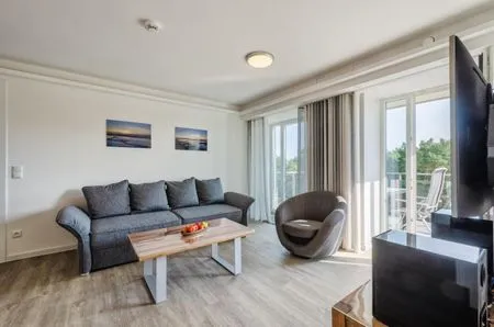 Wohnzimmer: Schlafsofa, TV, Zugang zum Balkon FeWo Ostwind in PRORA - 5.43