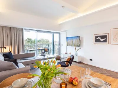 Wohn/Essbereich: Schlafsofa, Smart-TV, Zugang zum Balkon mit Strandkorb, Tisch und Stühlen FeWo Sanddorn in PRORA - 3.53