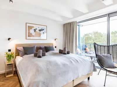 Schlafzimmer 1: Doppelbett (180x200), Kleiderschrank, Smart-TV, Zugang zum Balkon mit 2 Sonnenliegen FeWo Sanddorn in PRORA - 3.53