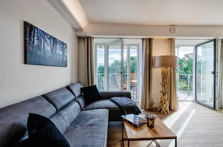 Wohnzimmer: Sofa, TV, Zugang zum Balkon FeWo Se(e)hnsucht in PRORA - 9.32