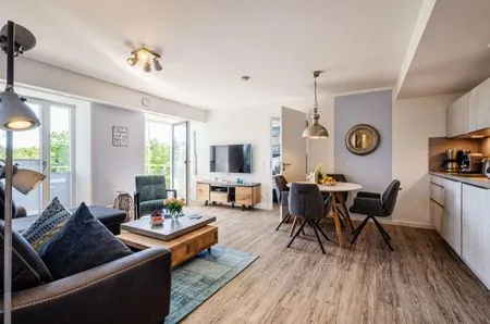 Wohnzimmer: Sofa, TV, Essbereich, Zugang zum Balkon FeWo Strandglück in PRORA - 9.44