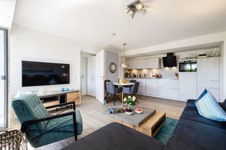 Wohnzimmer: Sofa, TV, Essbereich, Zugang zum Balkon FeWo Strandglück in PRORA - 9.44