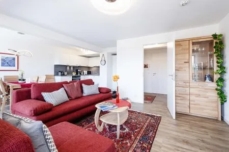 Wohnzimmer: Schlafsofa und Sessel, TV, Essbereich, Zugang zum Balkon FeWo Seemelodie in PRORA - 9.43