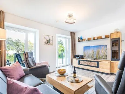 Wohnzimmer: Sofa, 2 Sessel, TV, Zugang zum Balkon FeWo Küstenliebe in PRORA - 2.21