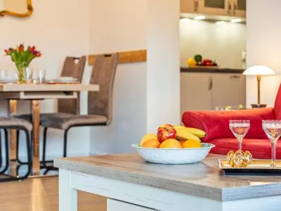 Wohnzimmer: Couch, TV, Essbereich, Zugang zum Balkon FeWo Seeigel in PRORA - 6.34