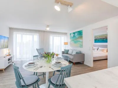 Wohnzimmer: Sofa, TV, Zugang zum Balkon und Dachterrasse FeWo Meerblick in PRORA - 2.55