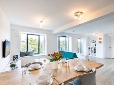 Wohnzimmer: Schlafcouch, TV, Essbereich, Zugang zum Balkon FeWo Dünenwald in PRORA - 6.44