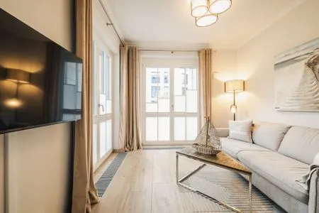 Wohnbereich mit Sofa und TV Logierhaus Friedrich WE 2 - "Strandrose"