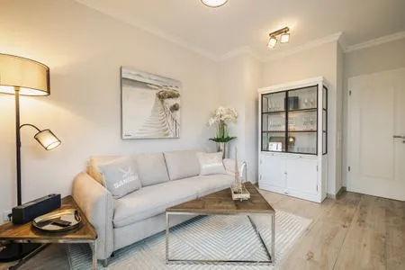 Wohnbereich mit Sofa und Vitrine Logierhaus Friedrich WE 2 - "Strandrose"