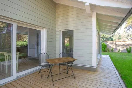 Einfamilienhaus Am Hafen 21 in Zieslow — überdachte Holzterrasse mit Sitzplatz und Blick in den Garten  Am Hafen 21