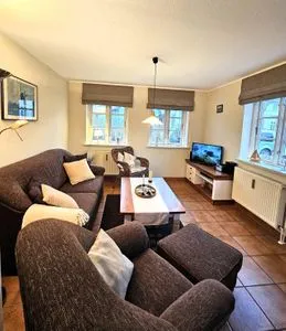 Gemütliches Wohnzimmer mit Sofa, Sessel und Fernseher. Am Museum - Wohnung 1