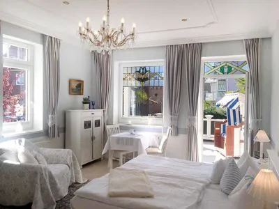 Wohnzimmer Villa Hansa App. C1 - mit Strandkorb und Palmen auf der Terrasse