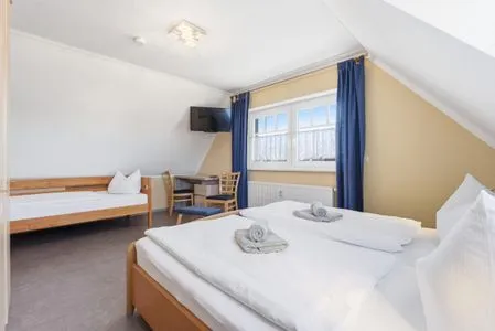 Schlafzimmer mit Doppelbett und einem Einzelbett  Glebbe 17 - Wohnung Südblick