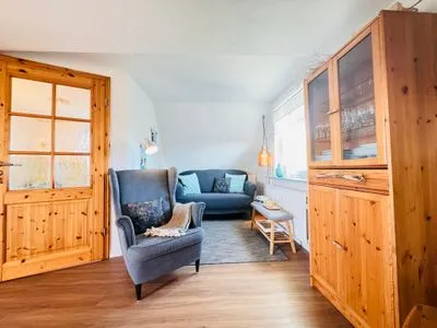 Wohnzimmer mit Sofa und Lesesessel, TV und Büchern Nordkiek No. 8