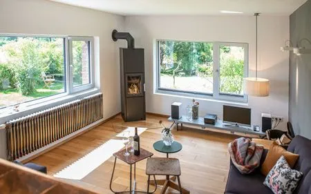 Helles Wohnzimmer mit Kaminofen und Blick in den Garten Ferienhaus Friedrich 15