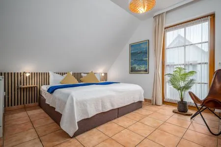 Schlafzimmer mit Doppelbett, Babybett und TV Ferienpark Freesenbruch Doppelhaushälfte 9a - Leuchtturm