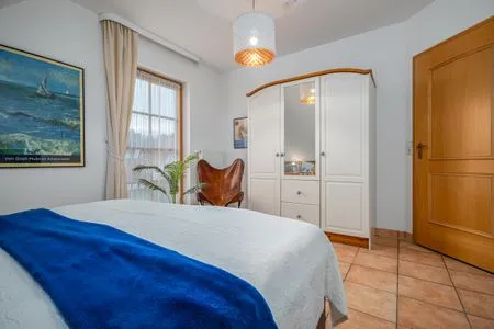 Schlafzimmer mit Doppelbett, Babybett und TV Ferienpark Freesenbruch Doppelhaushälfte 9a - Leuchtturm