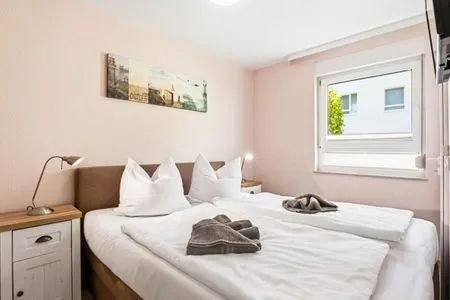 Schlafzimmer mit Doppelbett und TV Residenz am Strand Wohnung 4-57