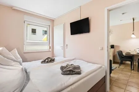 Schlafzimmer mit Doppelbett und TV Residenz am Strand Wohnung 4-57