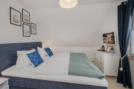 Schlafzimmer Ferienwohnung Strandlerche mit Balkon, Badewanne und Dusche