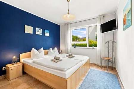 Schlafzimmer mit Doppelbett, Kleiderschrank und TV Residenz am Strand Wohnung 4-58