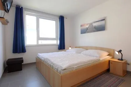 Schalfzimmer mit Doppelbett und TV Residenz am Strand Wohnung 4-59