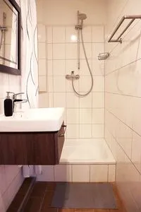 Waschbecken mit Spiegel und Dusche Strandnahe Souterrain-Ferienunterkunft - Mit gratis Bettwäsche-Paket