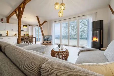 Offenes Wohnzimmer mit Couch, Meerblick, Ofen und Essbereich Westscheune am Mühlendamm
