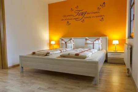 Schlafzimmer mit gemütlichen Farben und großem Bett Ferienwohnung Storchennest