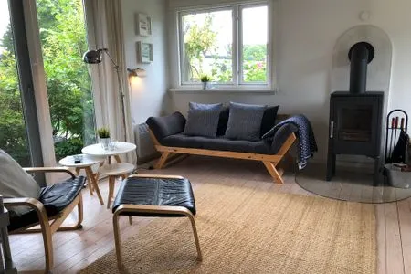 Wohnzimmer mit Couch, TV, Ofen, Essbereich Blaue Pause