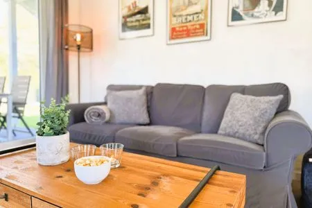 Wohnzimmer mit Couch, TV und Holzofen Fördezauber