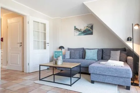 auf dem Sofa in der Ferienwohnung Carmen App. 12 liegen Kissen und eine Leselampe steht daneben Haus Carmen App. 12