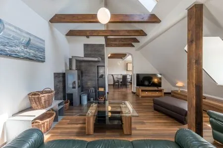 Ferienwohnung Seeperle Wohnzimmer mit Ofen und grüner Couch  Seeperle