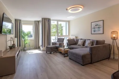 Ferienwohnung Godewind Aparthotel Zingst - Blick ins offene Wohnzimmer mit Couch und Sessel  Godewind