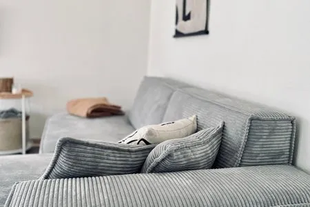 Wohnbereich mit Sofa, TV, Ofen und Zugang zum Wintergarten VITA Sonnholm