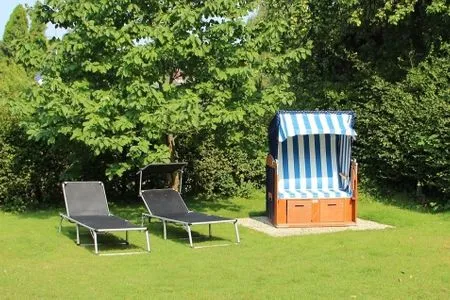 Genießen Sie entspannte Stunden auf dieser großzügigen Terrasse mit Liegen und Strandkorb. Haus Schiffchen