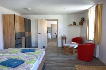 Schlafzimmer mit Sitzecke und Blick in Richtung Esszimmer Ferienwohnung Zur Sonne