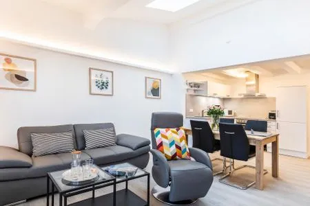 Wohn/Essbereich: Sofa, Sitzbereich, Essbereich, smartTV, Zugang zum Balkon mit Insektenschutztür, hoher Raum mit Dachfen FeWo Ausblick in PRORA - 8.52